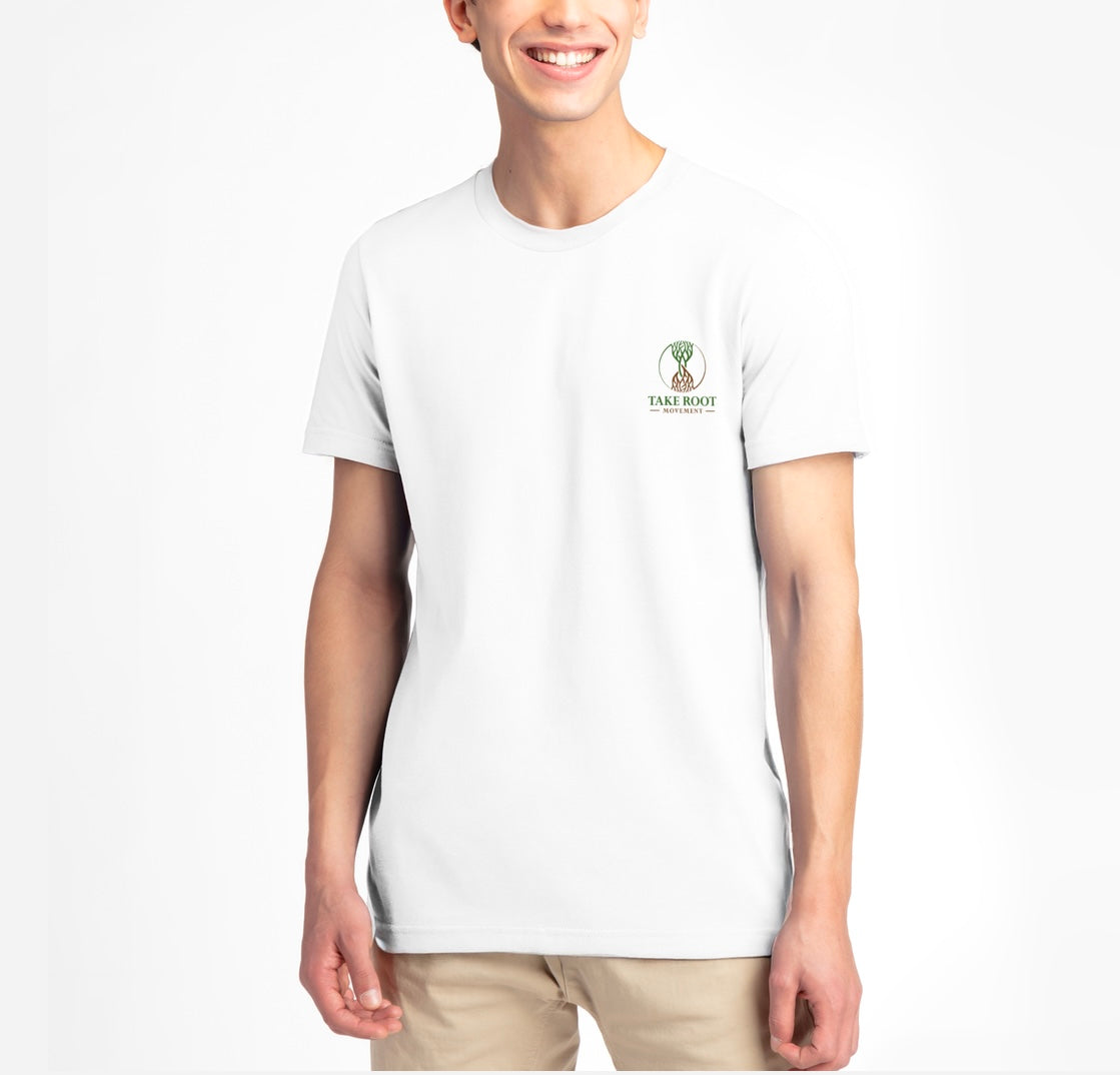 Person wearing white Christian T-shirt with ‘Take Root Movement’ text and green-to-brown rooted tree logo on the front.