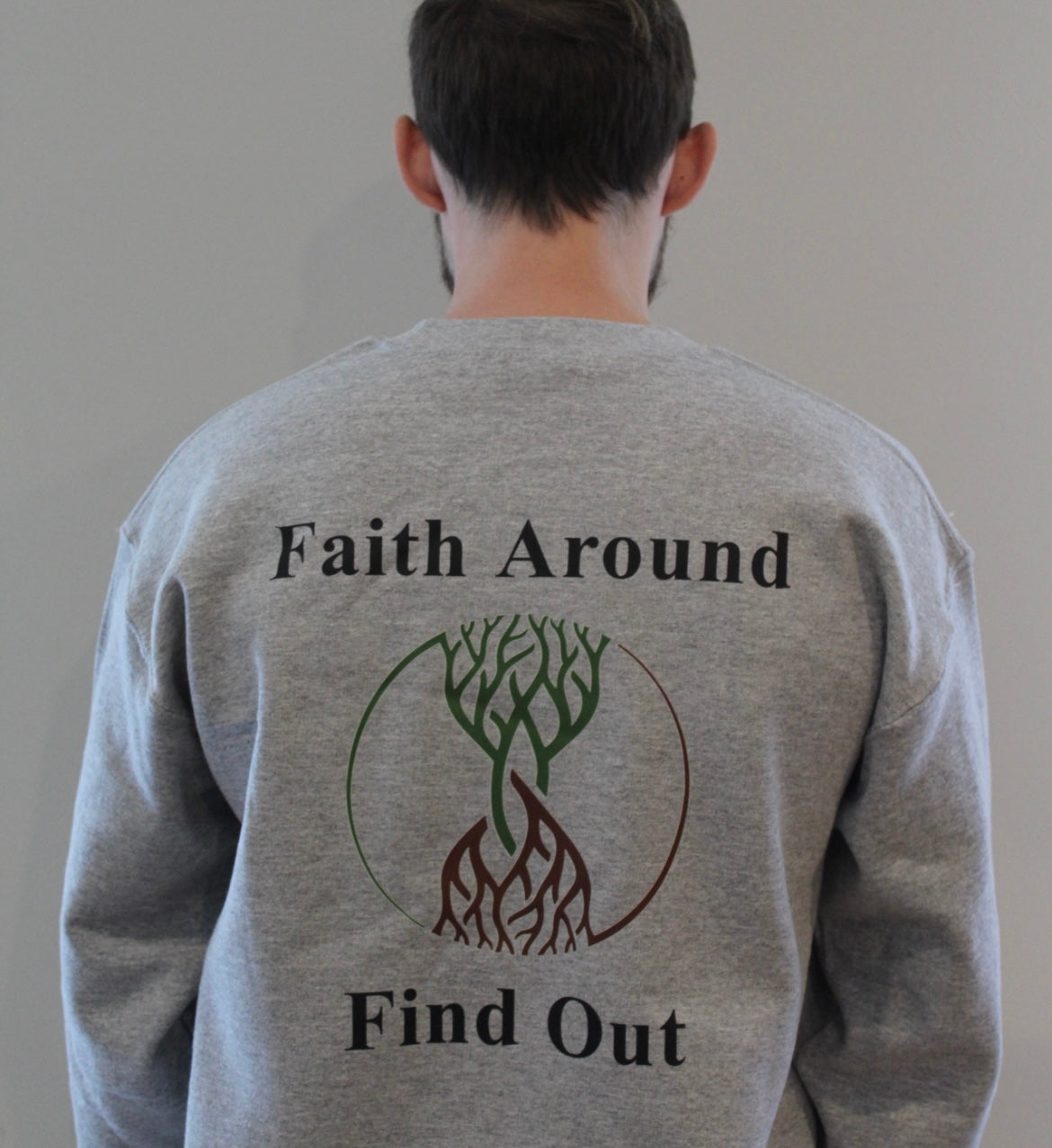 Grey Take Root Movement sweatshirt with ‘Faith Around Find Out’ text and intertwined tree-and-roots logo on the back.