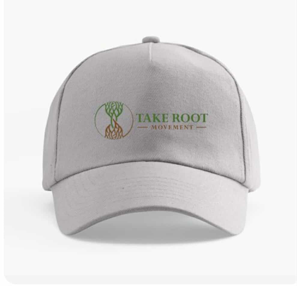 Light gray curved brim baseball cap with the Take Root Movement showing intertwined tree and roots on the front panel.  